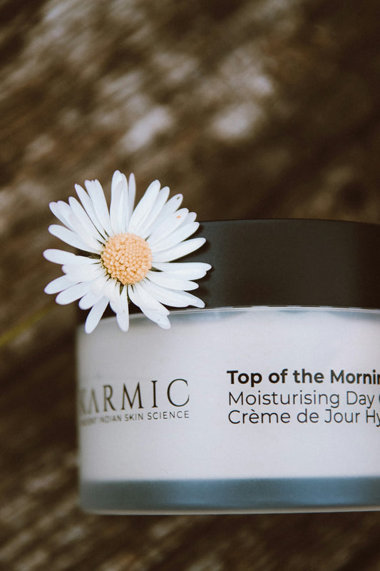 a jar of cream with a flower on top of it